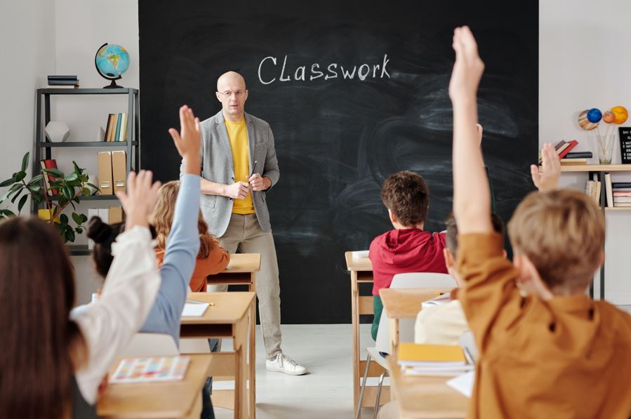 Niños levantando la mano en clase