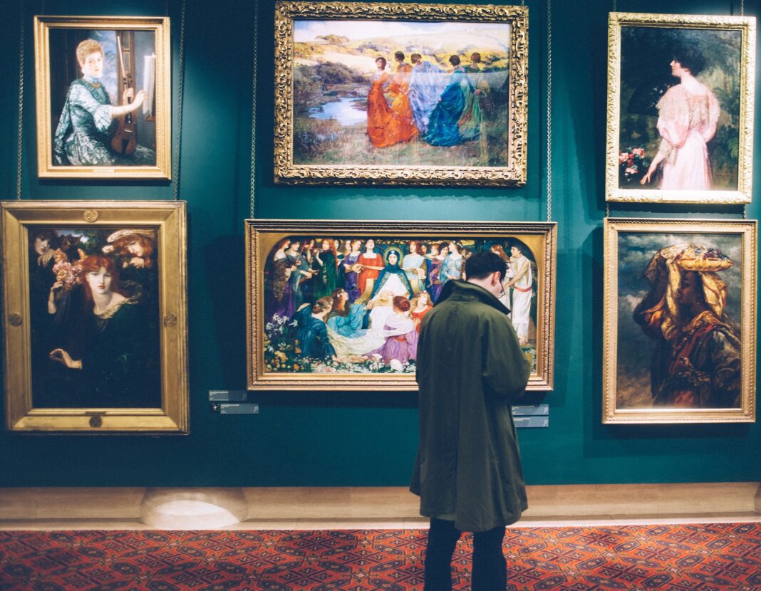 Hombre visitando una exposición de cuadros