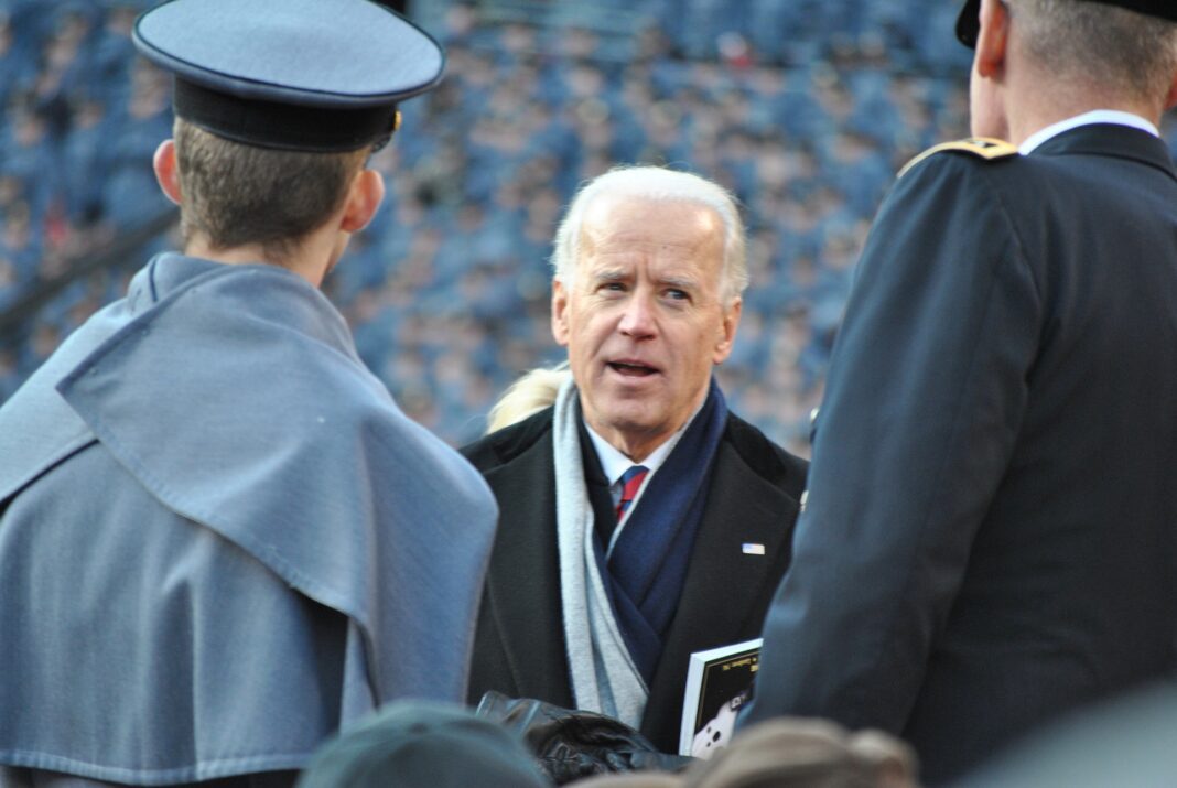 El presidente Biden charlando con dos oficiales de la Marina.