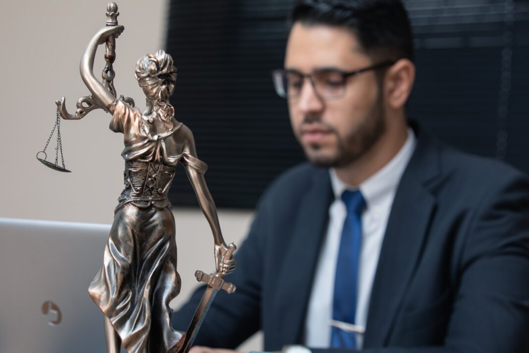 Abogado en su despacho con una figurilla que representa la justicia