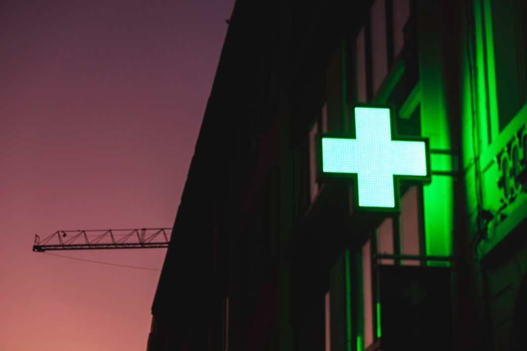 Cartel luminoso verde en el exterior de una farmacia