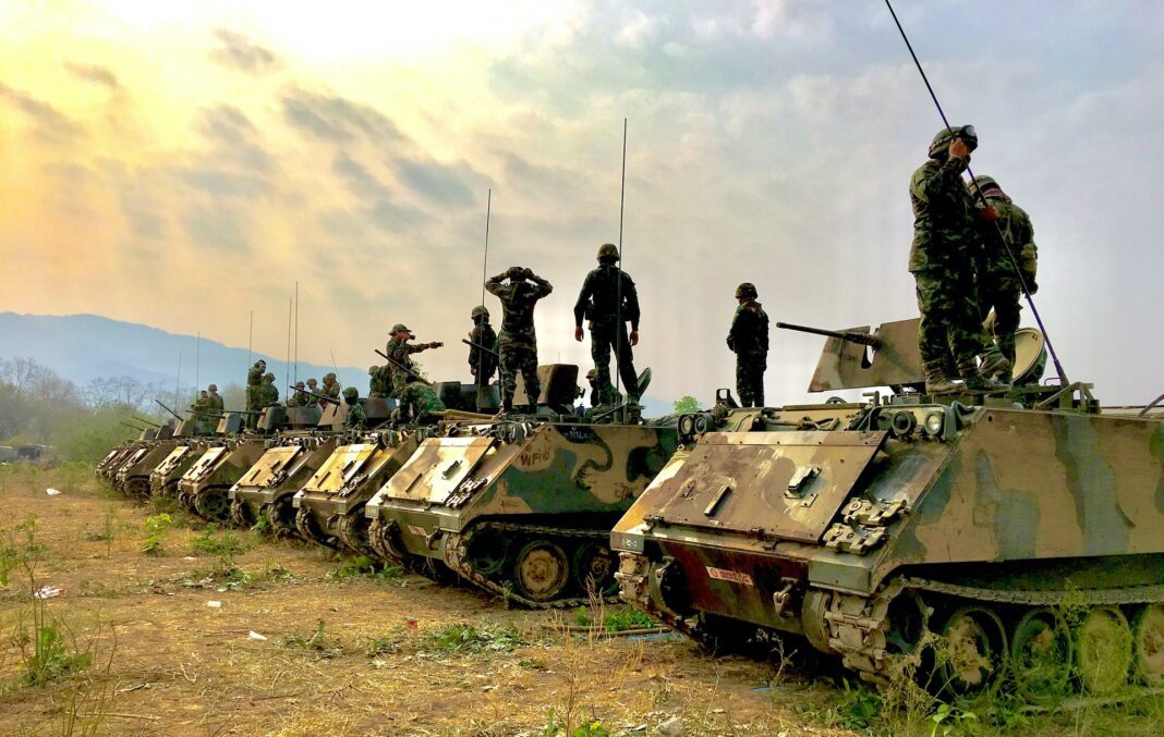 Ejército y militares subidos encima de tanques de guerra