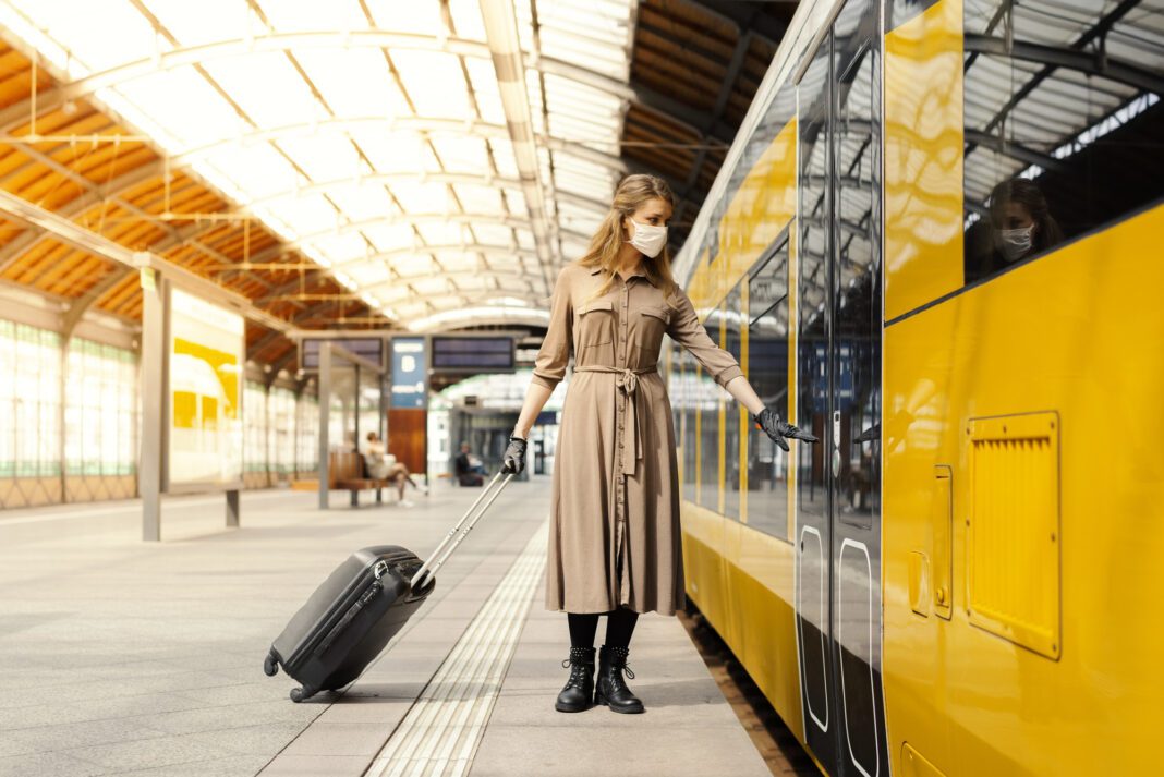 Mujer cogiendo un tren con una maleta