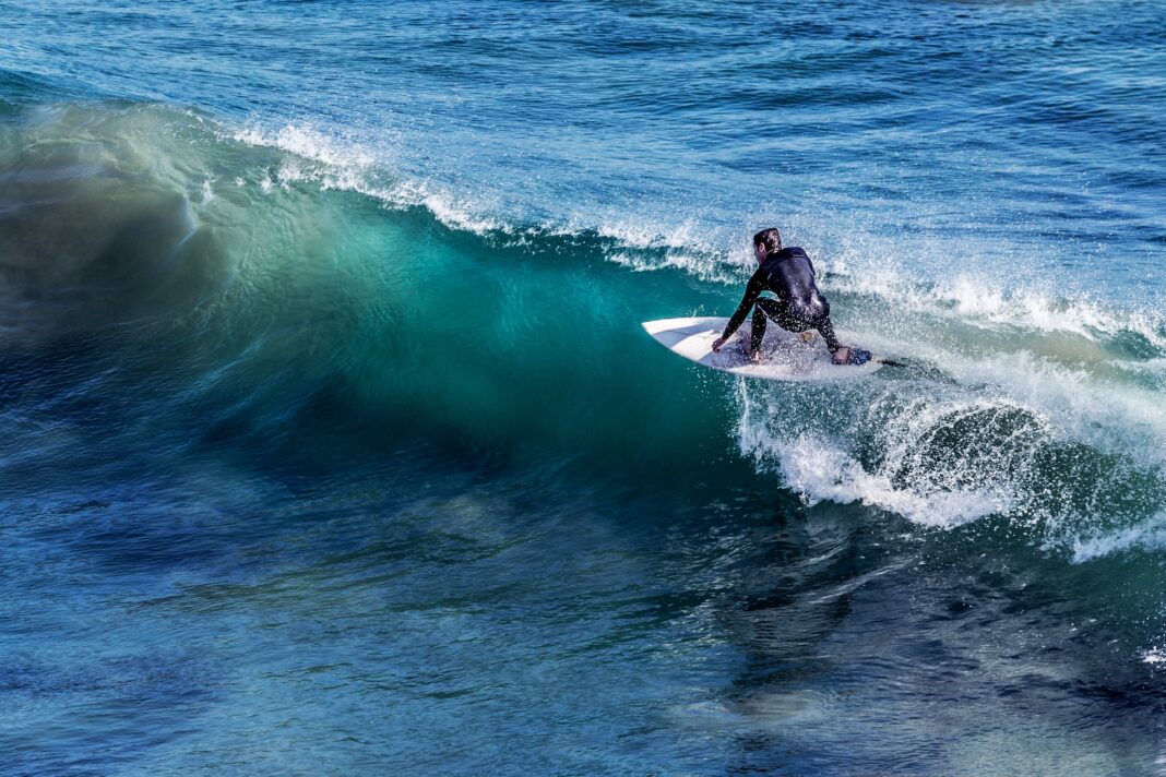 Deportista haciendo surf en una ola