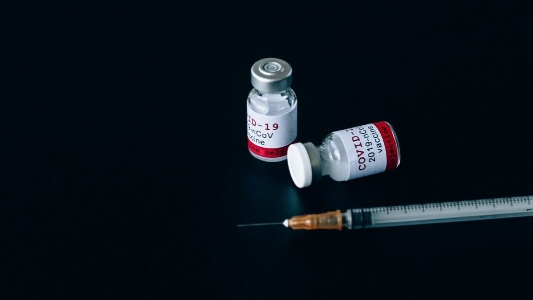dosis de la vacuna covid y una jeringuilla