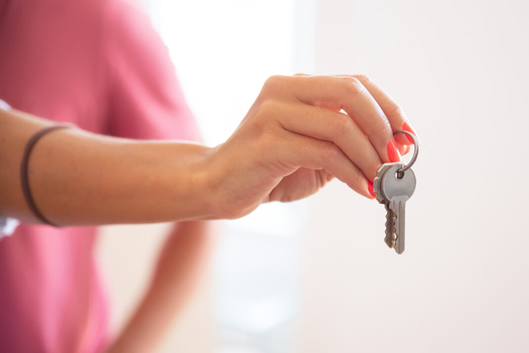 Mujer entregando las llaves de una casa