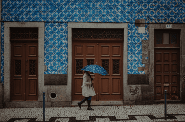 Mujer pasean por una calle con azulejos