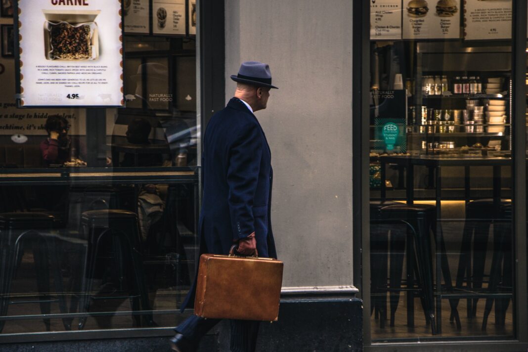 Detective privado con maletín andando por la calle